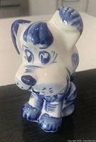 Front view of Gzhel porcelain dog figurine showing facial details and blue hand-painted accents