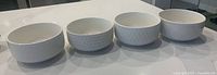 All four white embossed ceramic bowls in a row