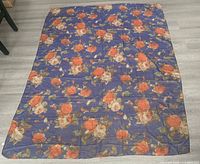 full view of rectangular silk scarf laid flat showing blue background and floral pattern