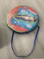 Folded SpringFloat lounger in retail wrapper, circular form with strap