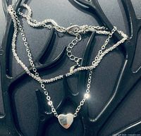 Full view of double-strand sterling silver anklet with heart charm and extender