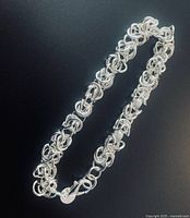 Close view of sterling silver woven bracelet and clasp showcasing interlocking rings