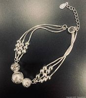 Full view of bracelet laid flat showing beads, multi-strands and clasp