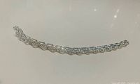 Full view of sterling silver triple strand bracelet laid flat