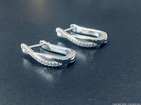 Side view of both earrings showing hinged hoop design and 925 stamp