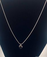 Full view of silver necklace on bust, showing chain length and pendant.