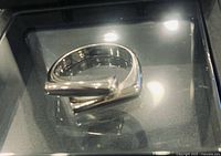 Ring in presentation box showing polished open geometric form