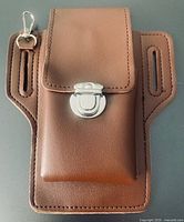 Front view of brown waist bag showing turn-lock flap, key clip and main pouch