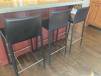 Three black bar stools at kitchen island