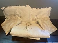 Folded bedspread, two shams, two throw pillows displayed