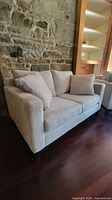 Loveseat angled view against stone wall