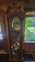 Front view of walnut grandfather clock showing full height and case details