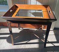 Full view of tray table showing wooden top, glass insert, metal legs