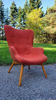 Front angled view of orange mid-century chair outdoors