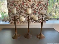 Three matching candelabras with candles and bead rings