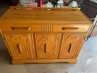 Front view of oak buffet showing drawers, doors, carving and brass pulls