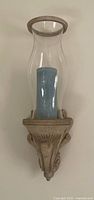 Front view of one sconce showing bracket, glass shade, candle