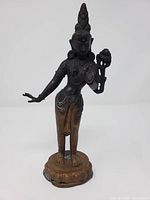 Front view of bronze Hindu goddess figure on pedestal