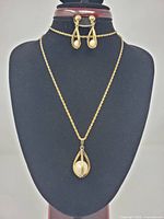 Full view of necklace and earrings on display bust