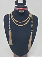 Full view of rope chain necklace/belt displayed on stand showing length and tassels