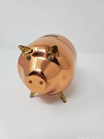 Front view showing copper body, brass ears, feet and slot