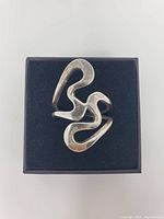 Top view of abstract sterling silver ring on black box