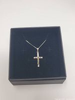 Necklace with cross pendant displayed inside black gift box