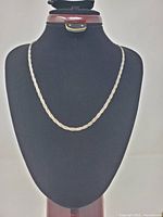 Full view of braided sterling silver chain on display bust