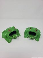 Pair of green ceramic frog ashtrays front view