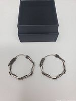 Pair of silver wire wrapped hoop earrings and black gift box