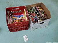 Overall view of red crate of magazines and white box of comics