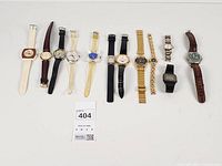 Group image of all eleven wristwatches laid in a row showing case styles, dial colours and strap types