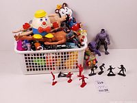 Full lot view showing basket overloaded with mixed figures, additional figures arranged in front