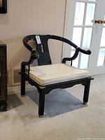 Front angled view showing entire chair with cushion and brass accents