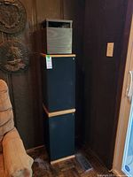 Full view of one tower speaker with cube subwoofer stacked on top