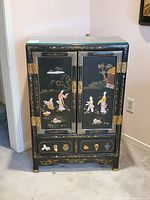 Front view showing doors, drawers, stone inlay and brass hardware