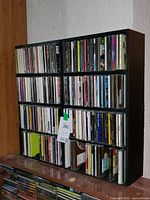 Full view of two black wooden CD racks filled with CDs