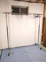 full view of chrome rolling garment rack with hangers