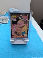 Front of Mark McGwire #46 rookie card in sleeve on stand