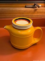 Side view of yellow Egersund teapot, handle visible