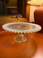 Side view showing pedestal base and ruffled opalescent rim