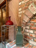 Full view of green glazed vase on hearth