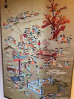 Full view of large embroidered panel showing gold silk background and detailed scene