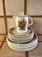 Stack of large plates with pitcher displaying pattern