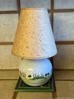 Full view of lamp with shade on green tile base