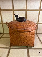 Front view of woven bamboo basket with whale lid handle