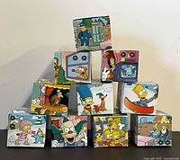 Eleven boxed watches stacked to show front artwork