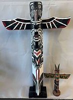 Front view of both totem poles showing relative sizes and painted detail