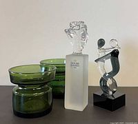 Front view of two Dansk green glass candleholders, Holmegaard rose candlestick, abstract figure