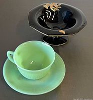 Jadeite teacup & saucer with black footed candy bowl side by side